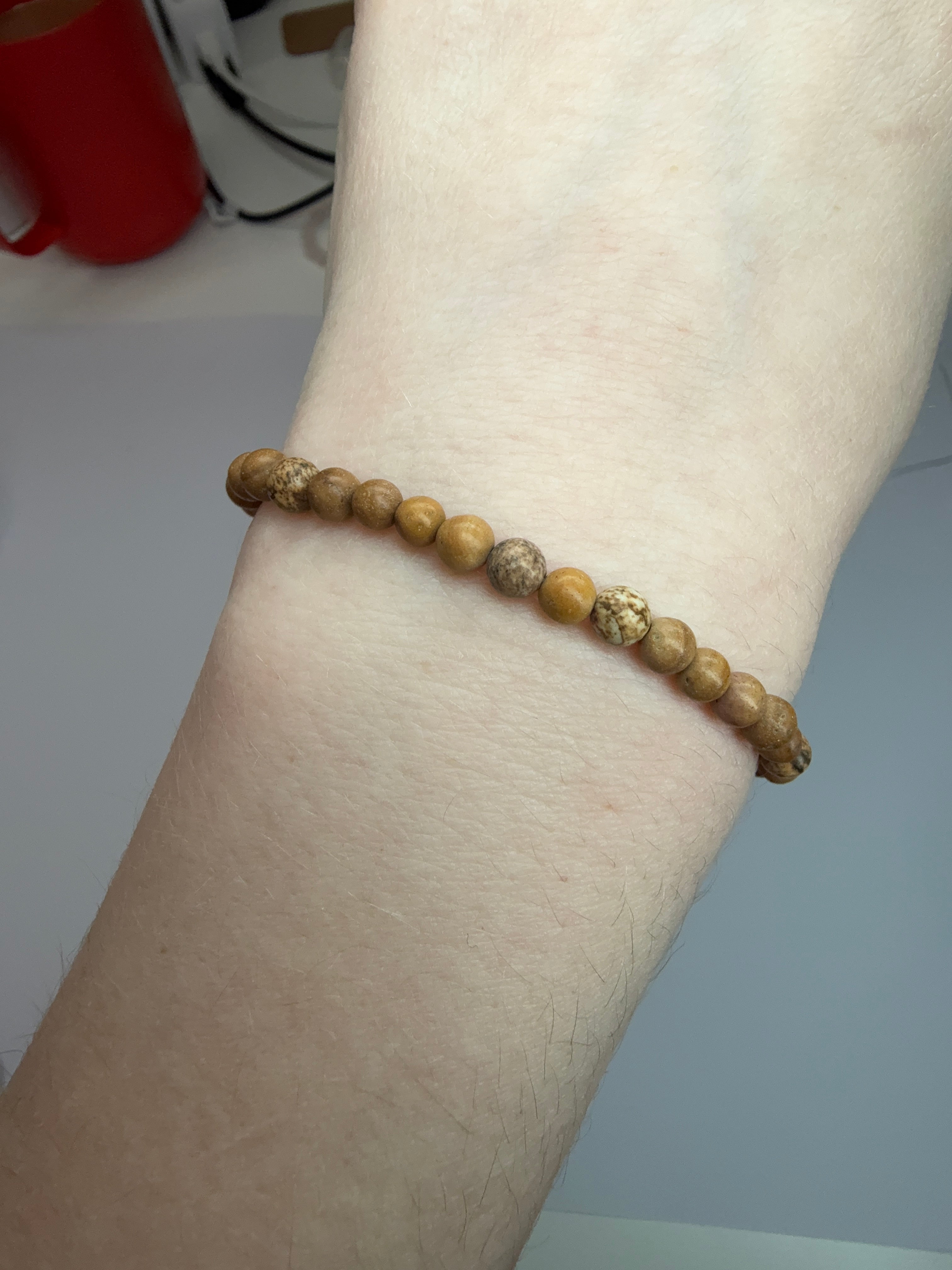 Beaded bracelet on a wrist with a neutral background