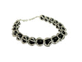 Bracelet with black beads and silver links on a light gray background